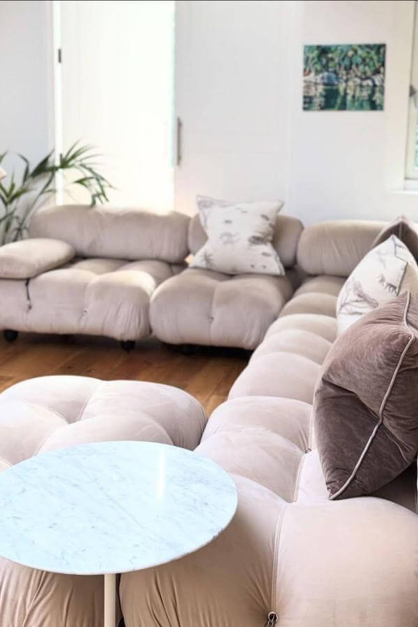 Sleek blue tufted sofa from @swiveluk. Perfect centerpiece for a mid-century modern living room.