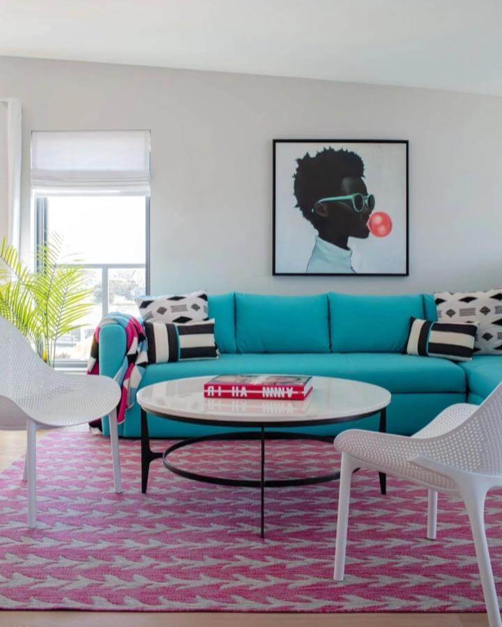 Turquoise sofa and pink patterned rug in a modern coastal living room ideas setting by @color.theory.boston.interiors creating a bright, playful vibe.