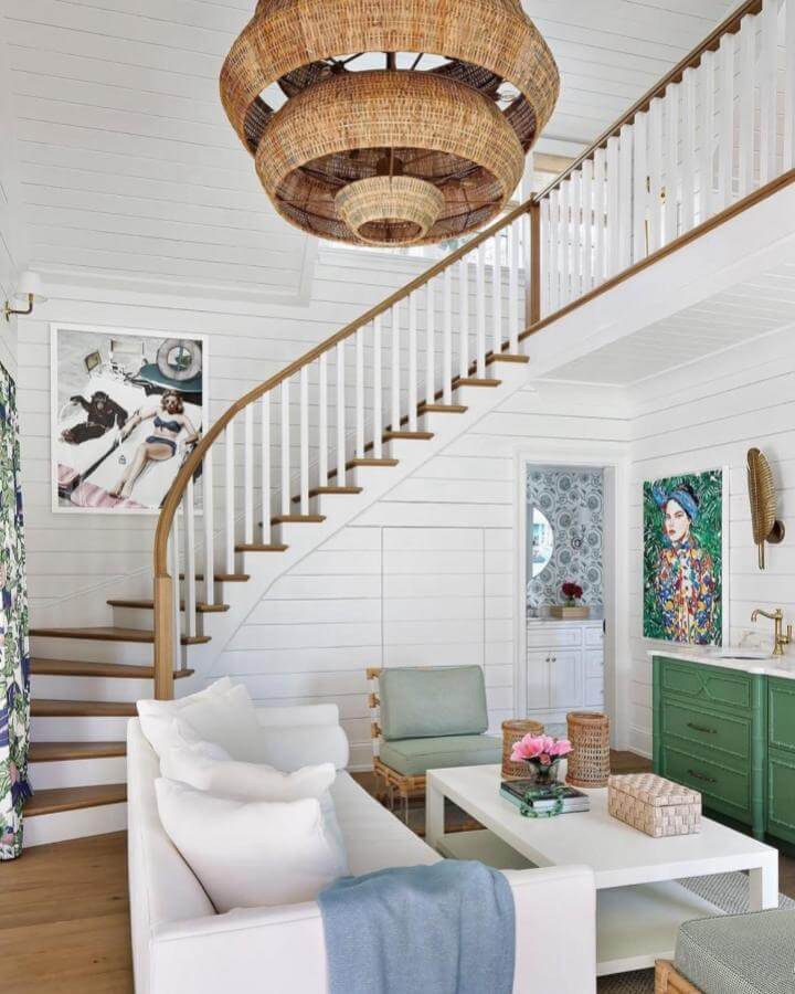 Natural woven rattan pendant light and coastal-inspired seating with soft white and green tones by @palettehome in a bright airy room.