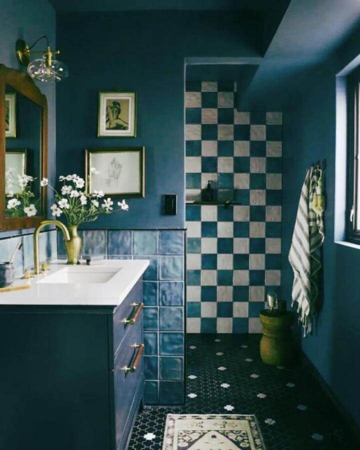Checkerboard tiles and deep blue walls bathroom by @modernlivingkitchensbathrooms showcasing textured moody bathroom style with brass and natural wood accents