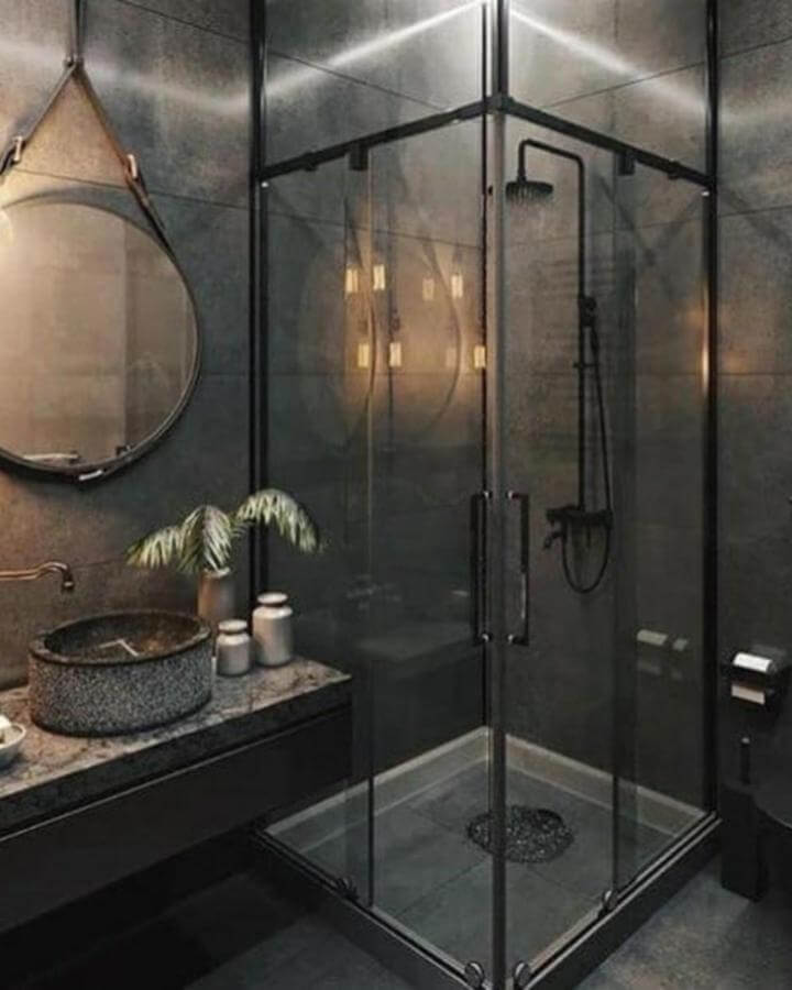 Dark glass shower enclosure and matte black fixtures bathroom from @balcondecor⁠. Industrial style with textured stone and intimate lighting.