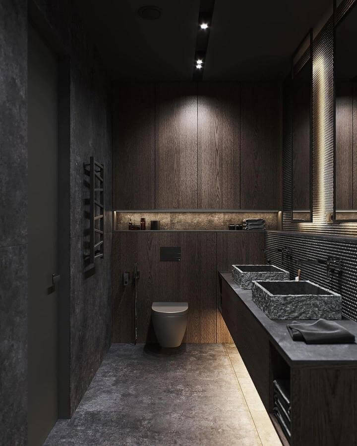 Rough stone sinks and dark wood cabinetry in a dimly lit bathroom by @nika.kryz showing textured, dramatic design elements.