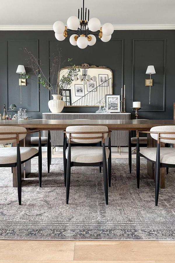 Moody dining room with modern chandelier; moody dining room ideas.