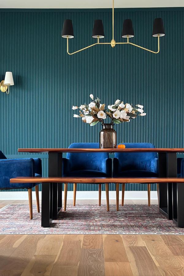 Moody dining room with textured teal wall; moody dining room ideas.