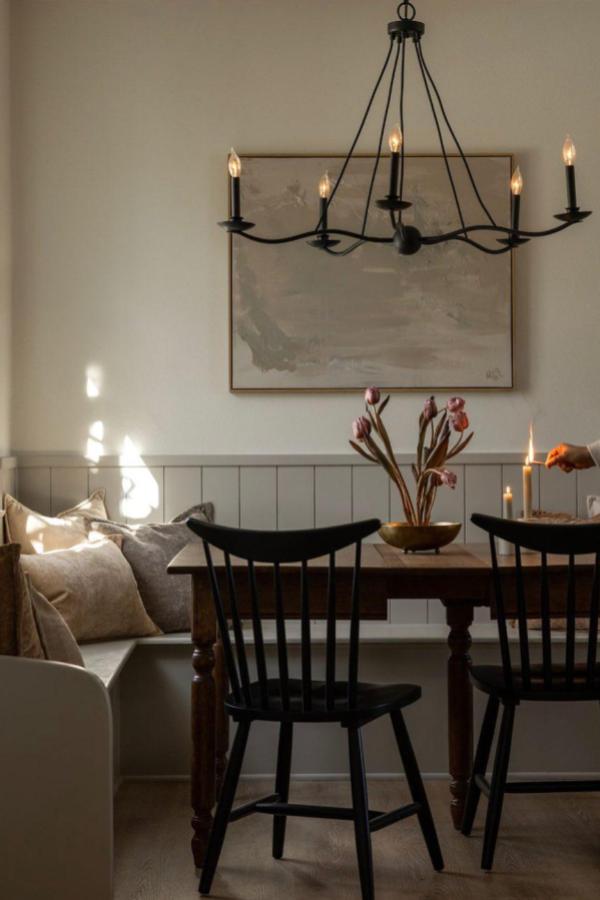 A moody dining room featuring black chandelier; moody dining room ideas.