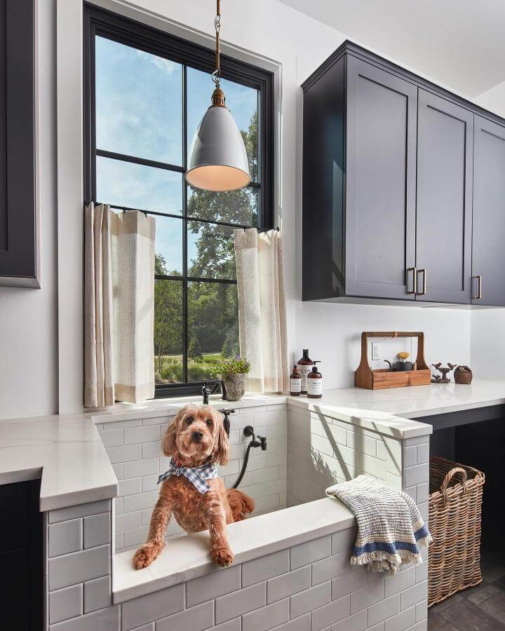 Bright clean subway tile dog wash station in mudroom dog wash ideas from @karlmosespics with dark cabinetry and natural light.