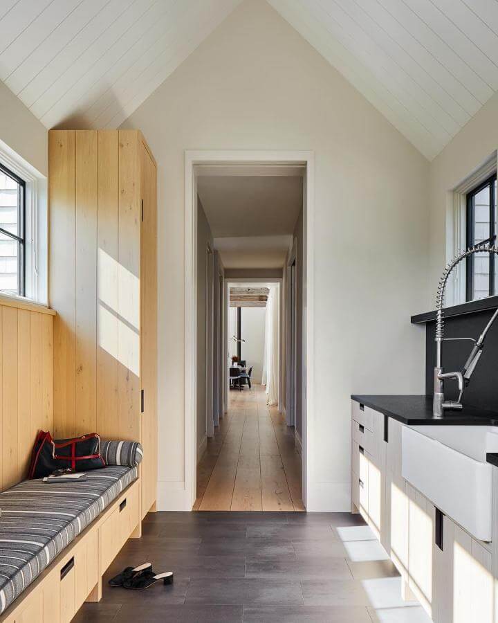 Light wood paneled mudroom with built-in bench and farmhouse sink by @readmckendree bright dog washing space.