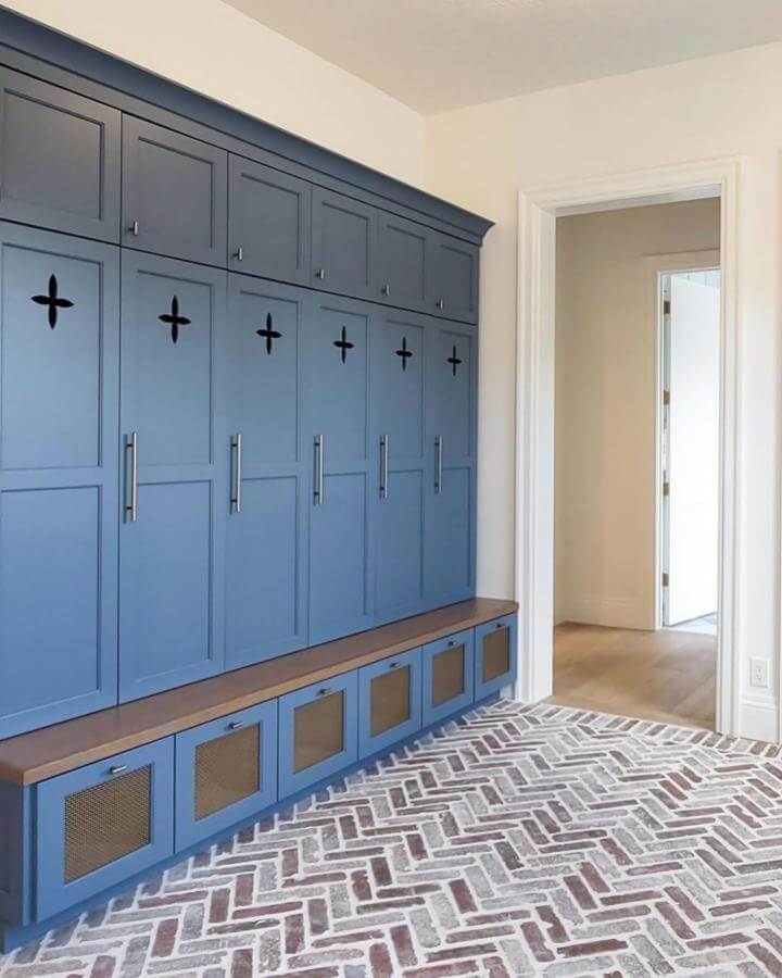 Brick flooring in herringbone pattern with red and earthy tones in mudroom by @owsiflooringanddesign complements blue cabinetry perfectly.
