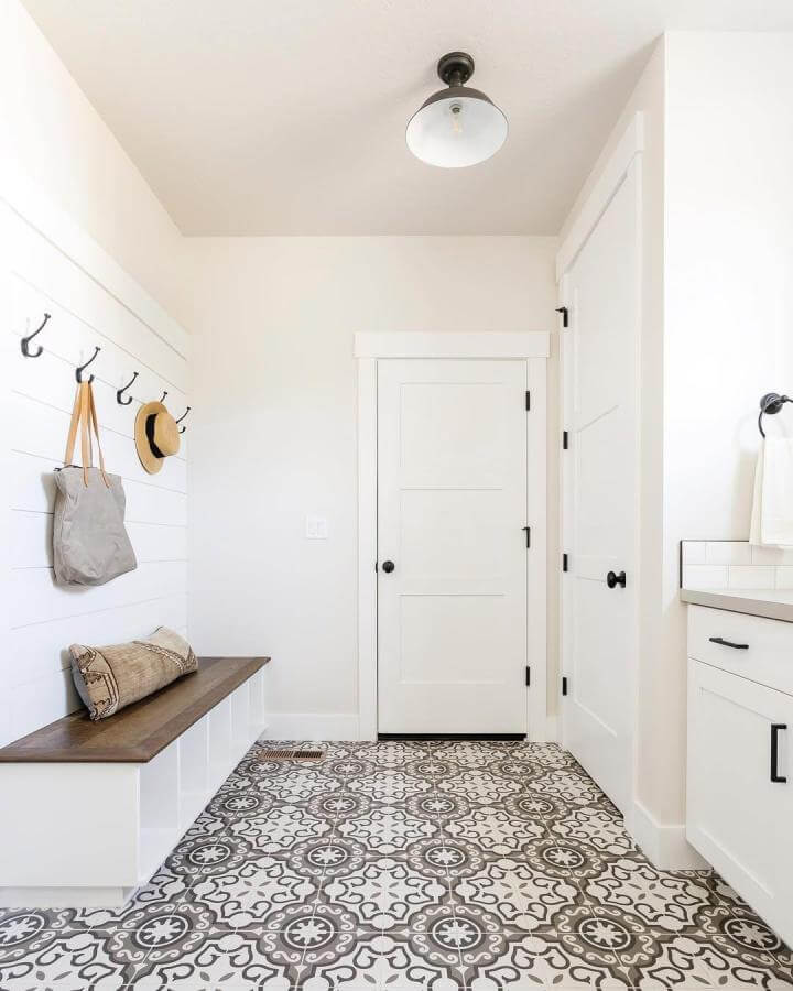 Gray and white patterned tile flooring in bright mudroom by @andimarshallinteriors featuring durable and stylish floor design