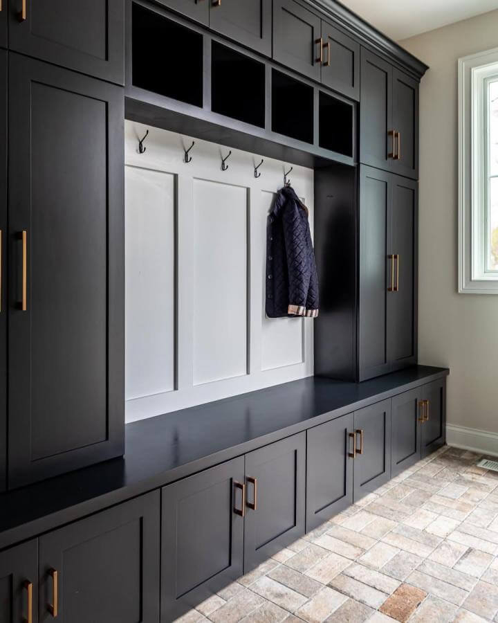 Chicago porcelain brick-look tile flooring in neutral shades in a mudroom with built-in black cabinetry from @oakleyhomebuilders. Durable and stylish floor design.