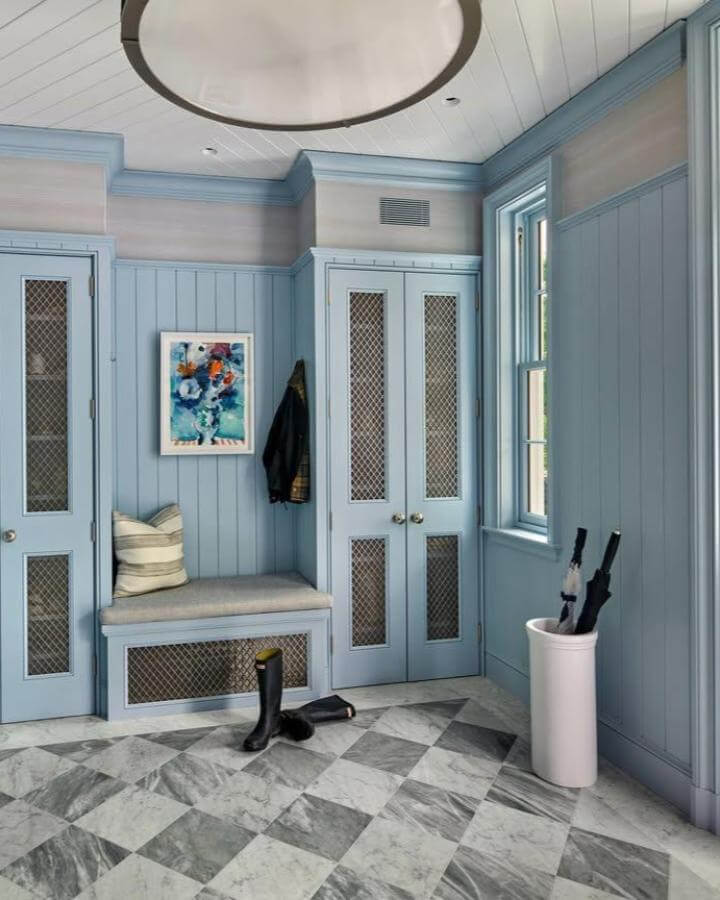 Checkerboard marble tile floor in coastal blue paneled mudroom from @vanderhornarchitects with classic built-in bench and storage.