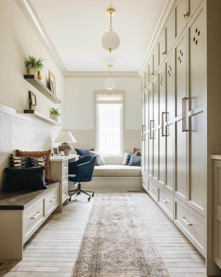 White tumbled marble tile flooring in a bright mudroom from @thetileshop. Soft, elegant mudroom flooring ideas with natural texture.