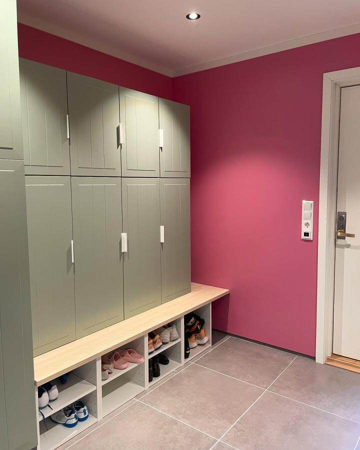 Sage green IKEA METOD cabinets with open shoe cubbies and vibrant pink wall in mudroom by @dortesunivers showcasing mudroom shoe storage ideas