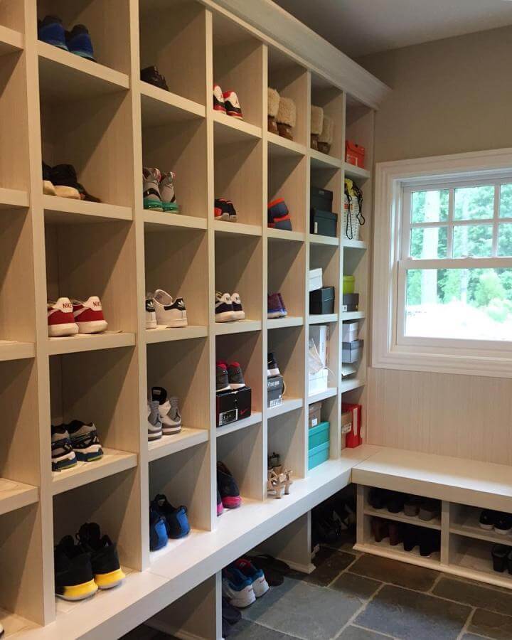 Light wood cubbies and bench with stone tile floor in mudroom by @amidesigns. Neat shoe compartments and natural tones create organized entryway.