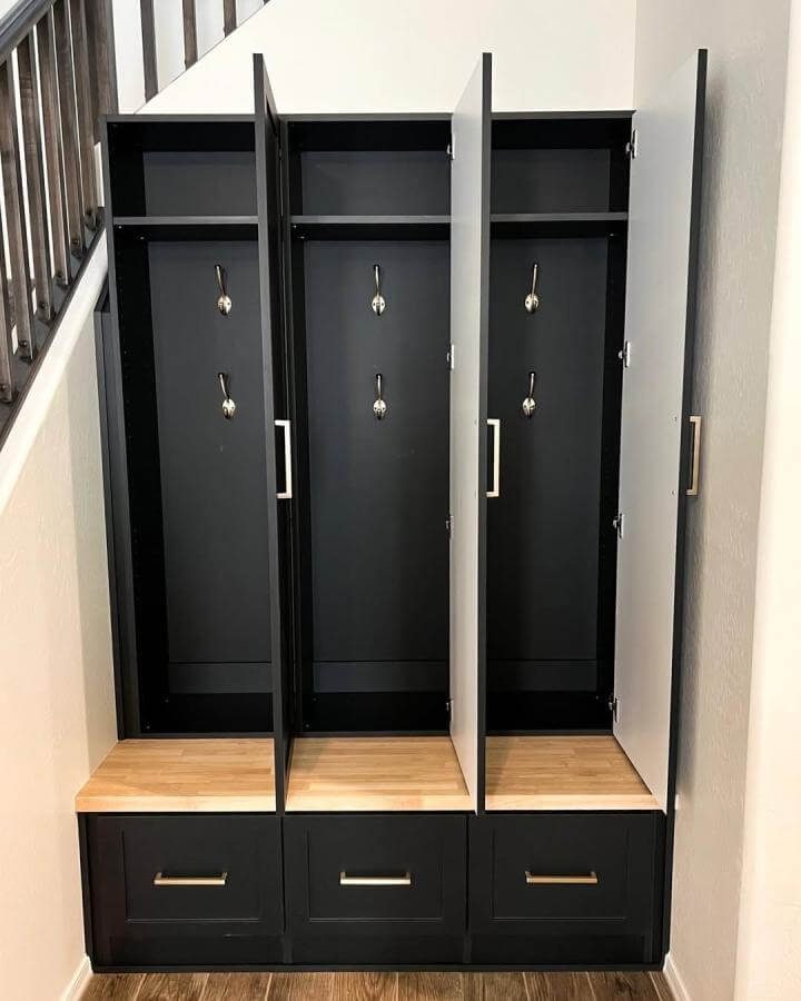 Black mudroom lockers with wood bench from @spacesolutionsaz. Built-in hooks and sleek handles create organized shoe and coat storage.