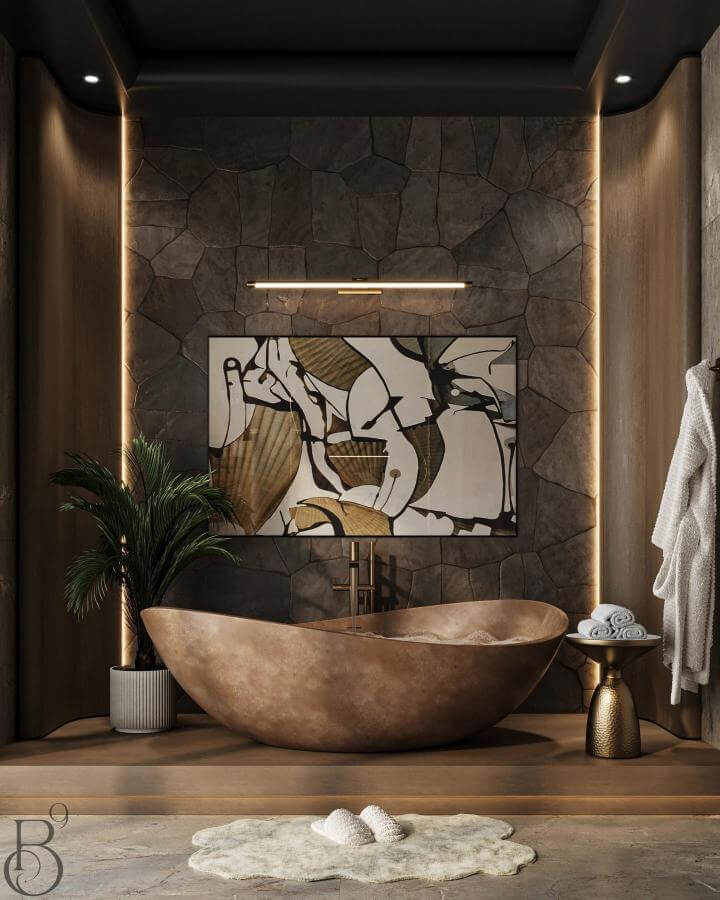Brown sculptural stone bathtub with rough stone wall and ambient lighting in luxurious bathroom by @base9studio natural stone bathroom ideas.