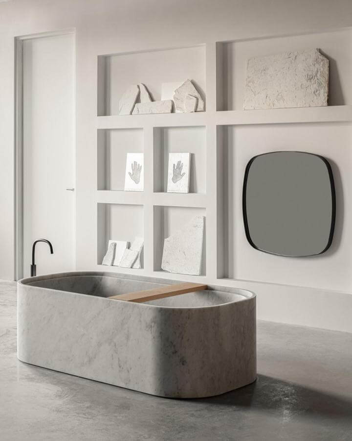 Carrara Marble bathtub with raw stone display and minimalist design from @cafeine natural stone bathroom ideas modern elegance.