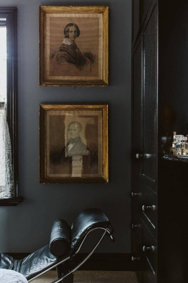Vintage black-and-white portraits on navy bedroom walls from @yourhomeandgarden. Add dramatic, timeless charm.