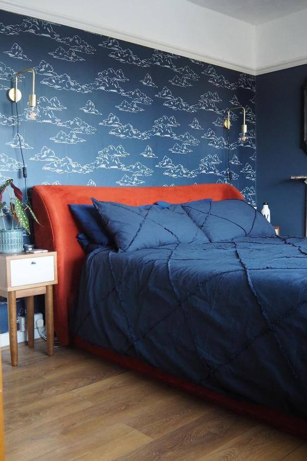 Whimsical cloud wallpaper sets a dreamy scene in navy bedroom from @shiptoria. Soft, airy, and soothing ambiance.
