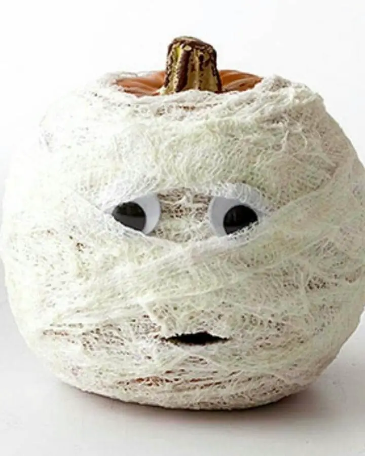 White gauze-wrapped mummy pumpkin craft from @ralphandfeather showcasing creative no carve pumpkin ideas with googly eyes.