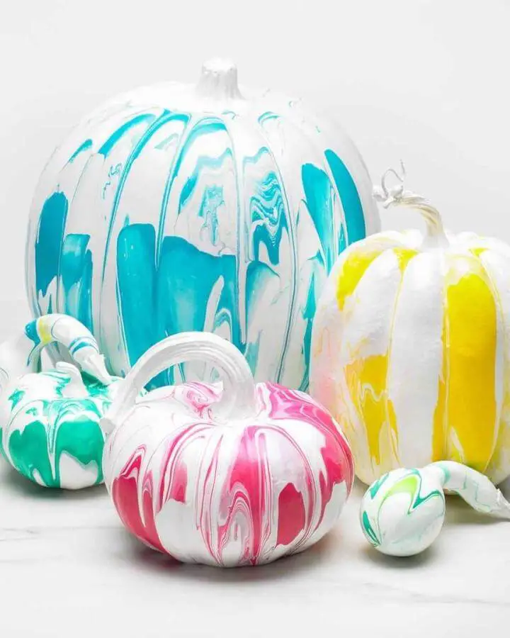 Colorful marbled paint pumpkins with turquoise, yellow, and pink swirled designs from @plaidcrafts.