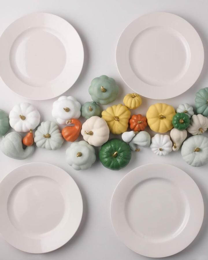 Colorful painted mini pumpkins arranged as table centerpiece showing creative no carve pumpkin ideas from @plaidcrafts