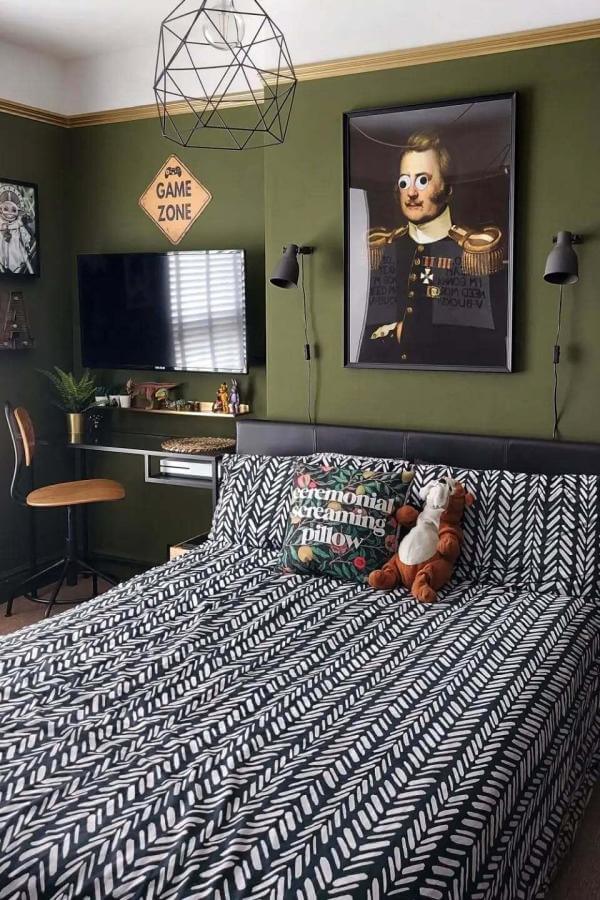 Playful colorful portrait art brightens olive green bedroom walls from @mrsgregsie, adding whimsical character and charm.