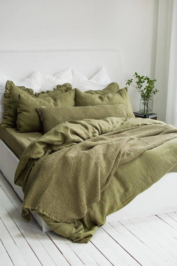 Cozy olive green layered duvet on bed from @grannethomelinen. Inviting texture for peaceful bedroom ambiance.