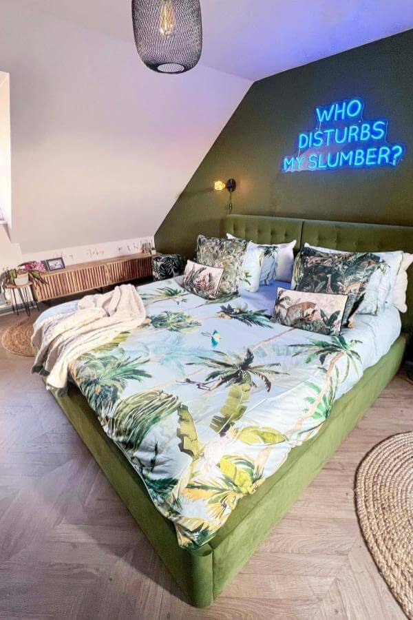 Neon blue glowing letters wall art from @awholenewbuild. Adds whimsical tropical flair to olive green bedroom.