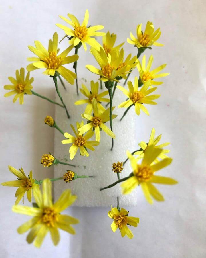 Yellow crepe paper wildflowers with green wire stems from @daydream_flowers showing realistic handmade paper crafts for adults bouquet.