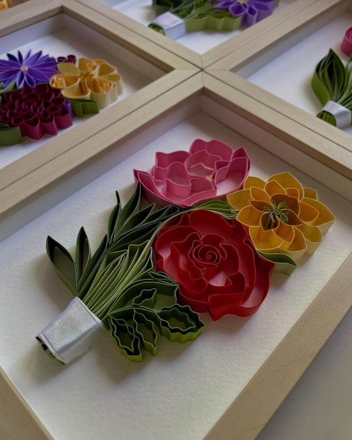 Pink red and yellow quilled paper flower bouquet framed art from @adriennkg_paperart showcasing paper crafts for adults with curled petals and green leaves.