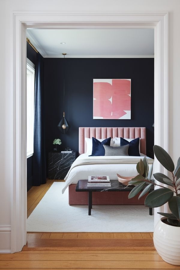 Pink and navy bedroom featuring plush bedding and patterned pillows.