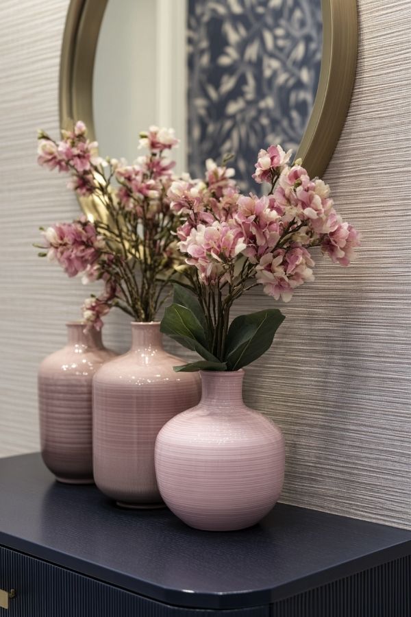 Pink and navy bedroom with floral accents and cozy lighting.