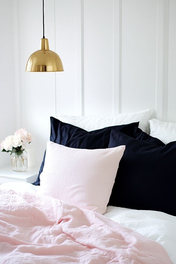 Pink and navy bedroom with elegant decor and cozy atmosphere.