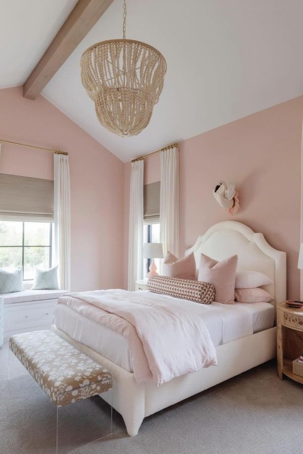 Cozy light pink bedroom featuring boho decor elements and textures.