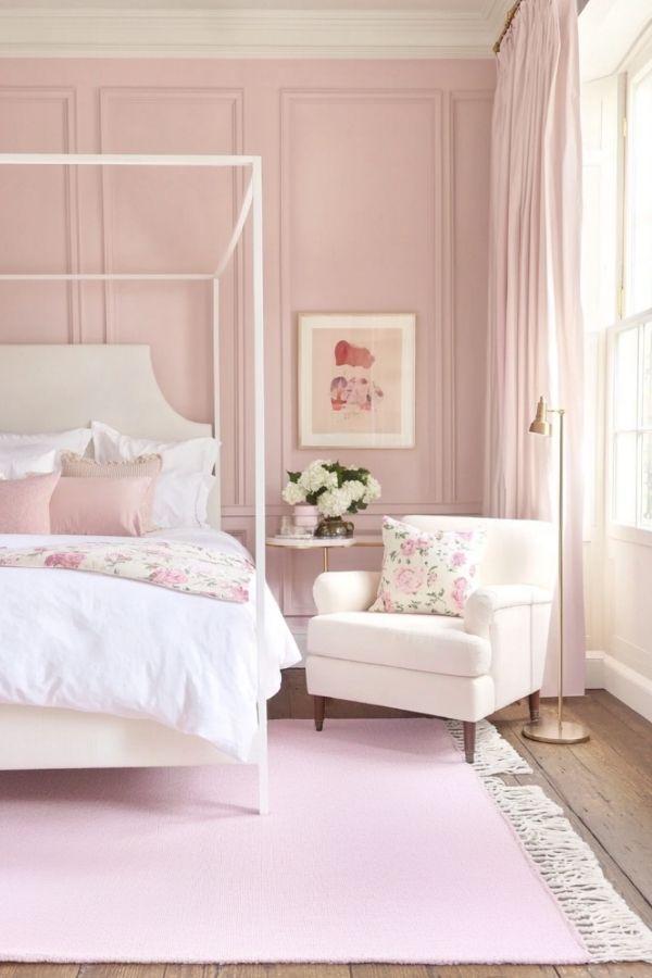 A soft pink romantic canopy bed with elegant, flowing drapes.