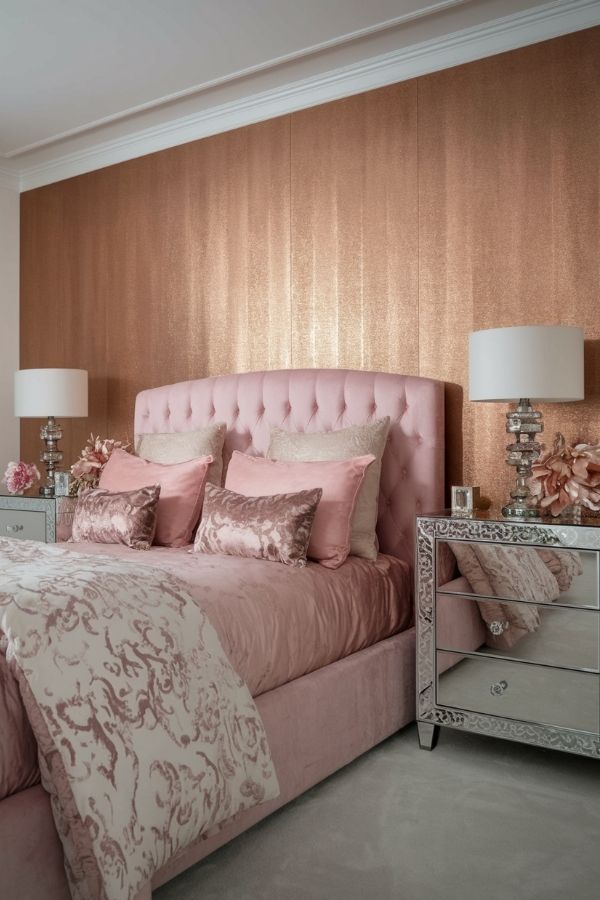 Stylish pink bedroom featuring metallic accents, plush bed, elegant decor.