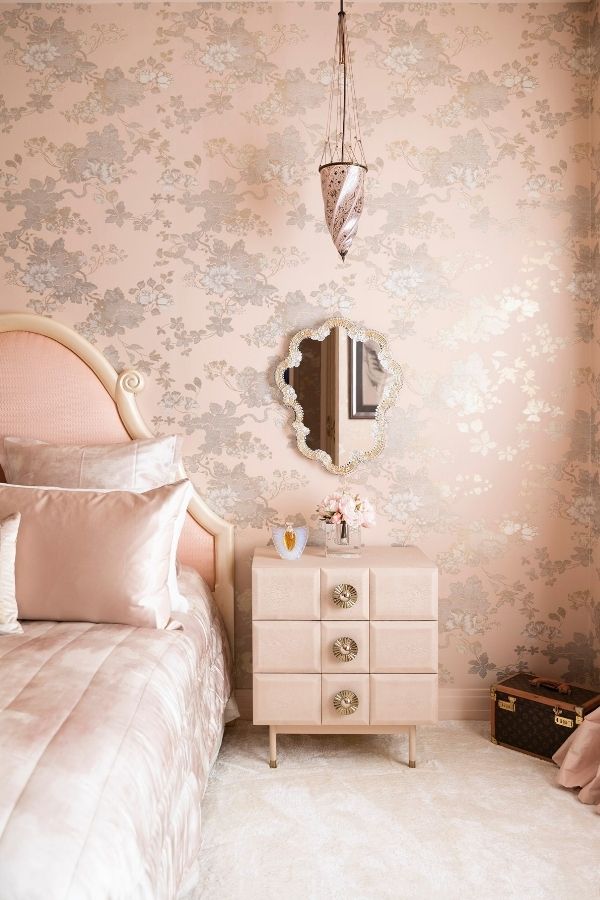 Elegant pink bedroom featuring vintage decor and soft lighting.