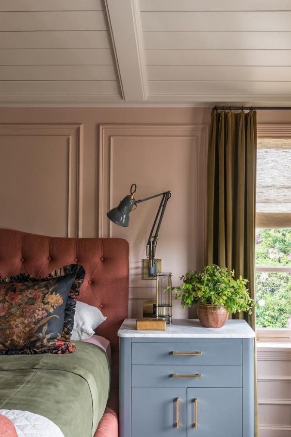 Cozy vintage bedroom with muted pink hues and classic decor.