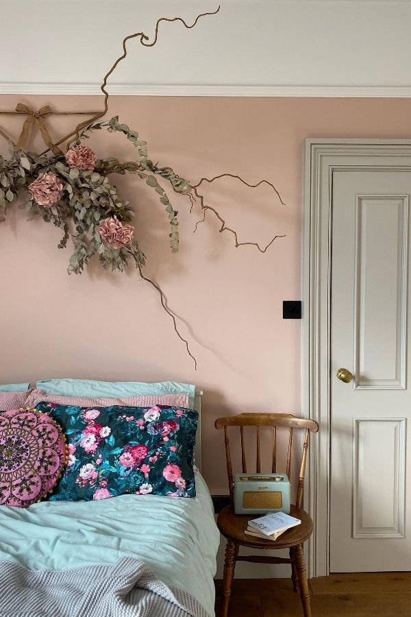 Soft pink bedroom featuring floral wall art, cozy and elegant.