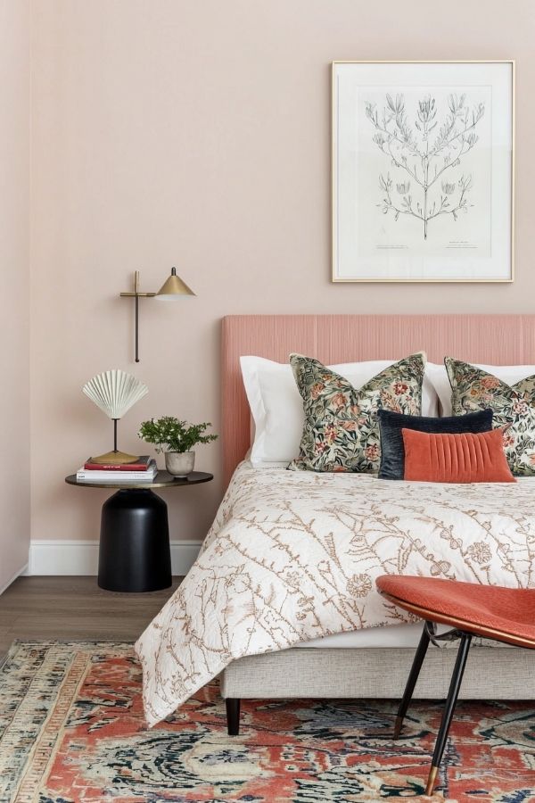 Serene pink bedroom featuring artistic decor, soft lighting, cozy atmosphere.