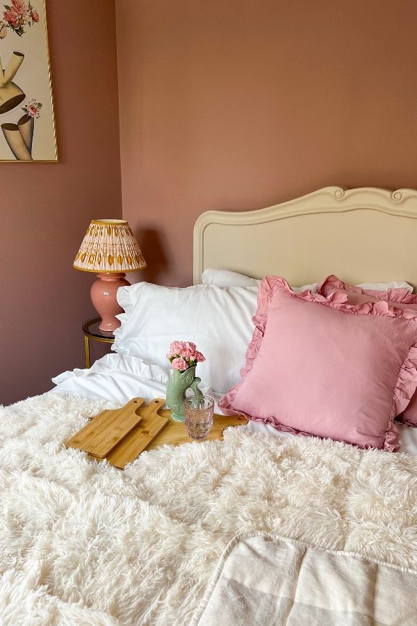 Cozy pink bedroom featuring plush bedding and soft lighting ambiance.