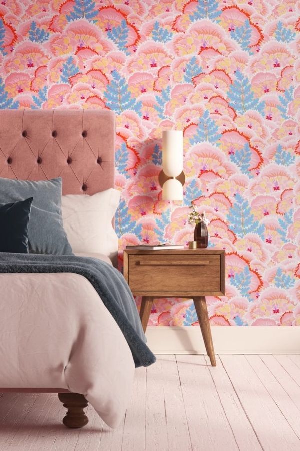 Vibrant pink bedroom, floral wallpaper, cozy ambiance, stylish decor, inviting.