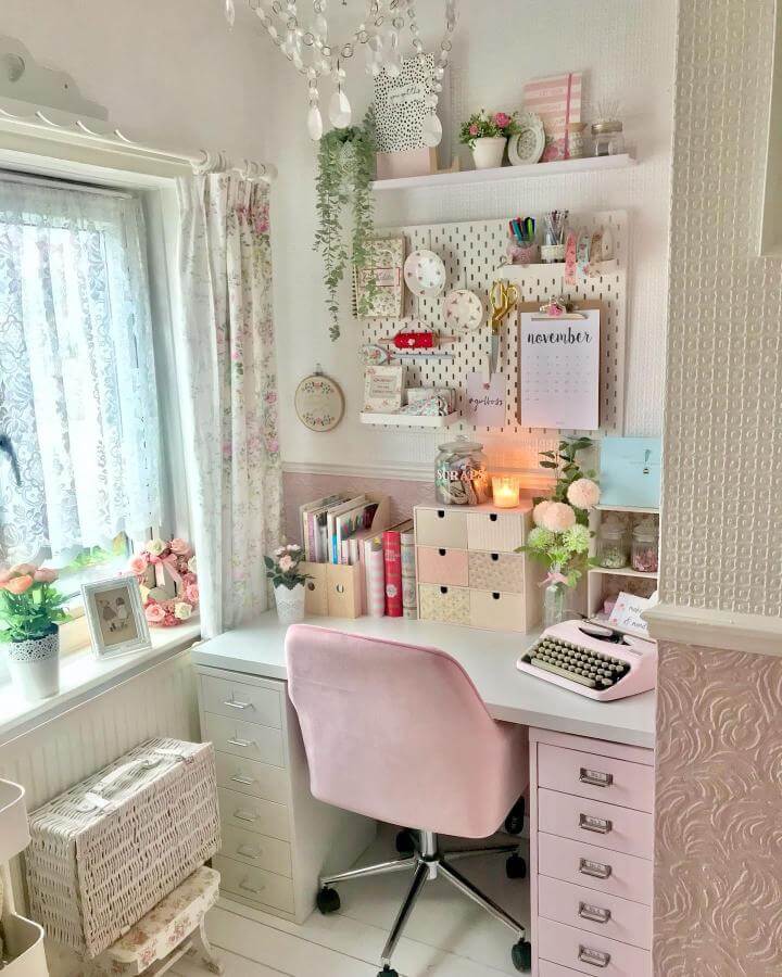 Soft pink velvet chair with white desk and floral accents in a cozy crafting space from @little_pink_crafter with elegant storage and decor.