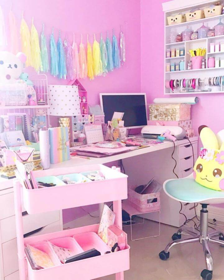 Pink craft room with rolling storage cart, colorful ribbons on shelves, and pastel accents by @diaxdiary creating organized lively workspace