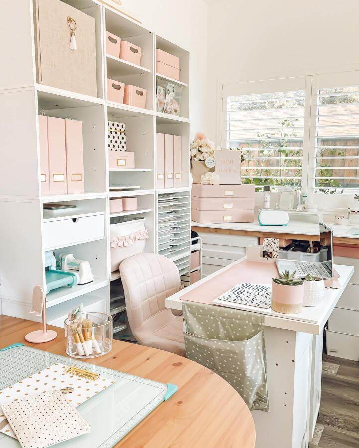 Soft pastel pink storage bins and boxes neatly arranged in a bright craft room by @diyvinci with white shelving and natural light.