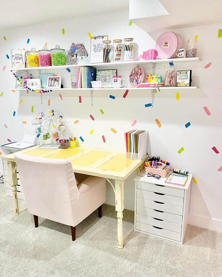Pink velvet chair in cozy craft room by @dani_leigh_cosplay featuring a pastel pink craft room ideas aesthetic with colorful decor and shelving.