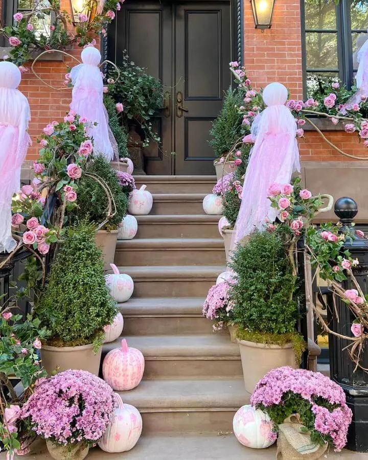 Blush front porch steps from @blushandblooms featuring pink halloween decor ideas with pumpkins and purple mums.