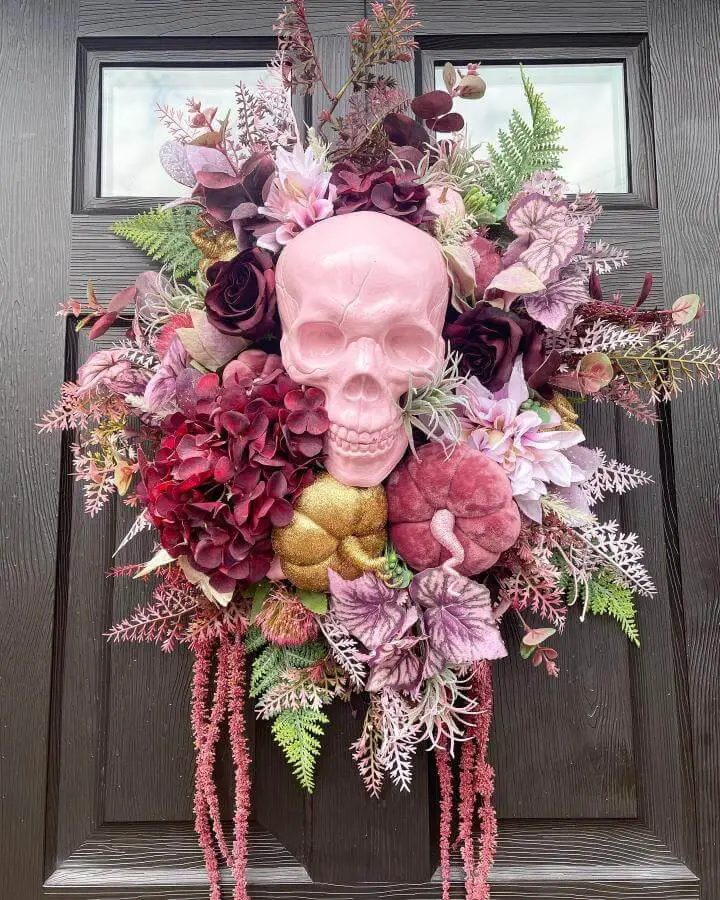 Elegant pink skull wreath from @gattenbys_decor featuring burgundy florals and cascading elements for pink halloween decor ideas.