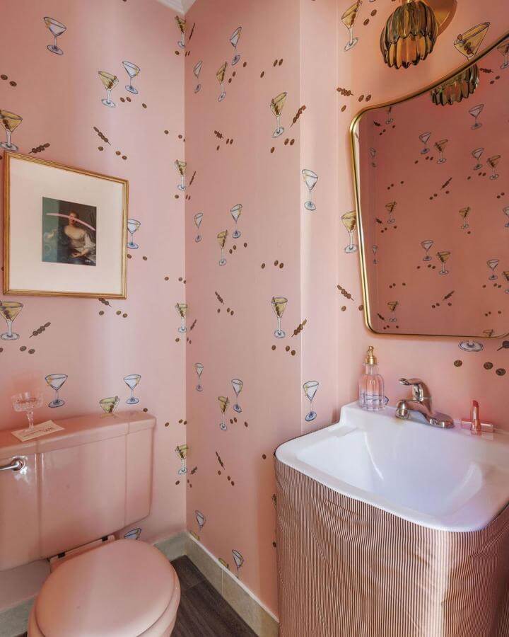 Pink powder room ideas featuring playful cocktail wallpaper and vintage pink fixtures from @ethnikliving. Retro chic and fun ambiance.